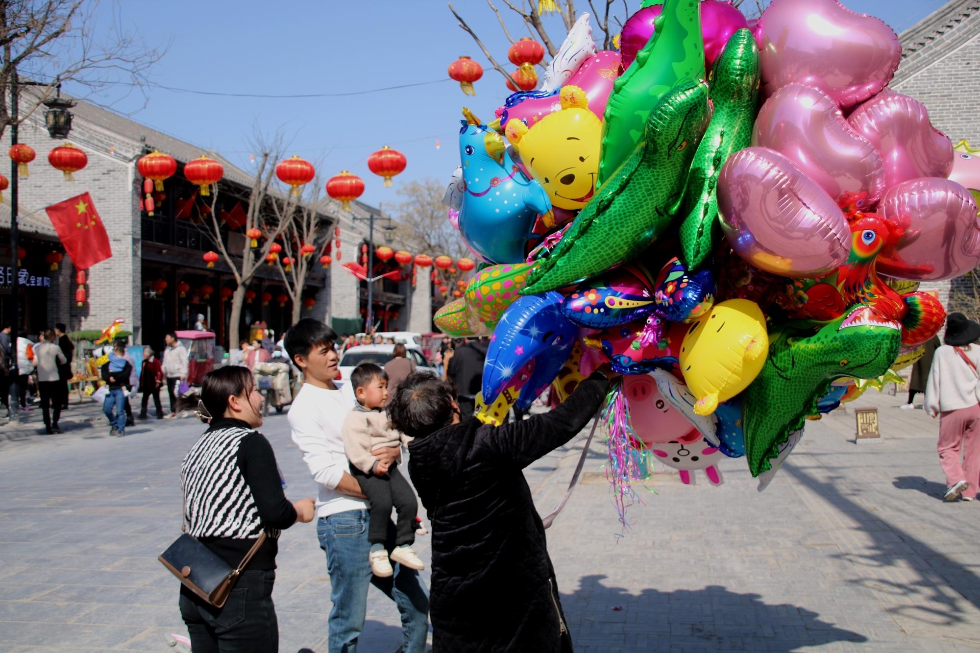 游客在为孩子购买气球.李德鹏 摄
