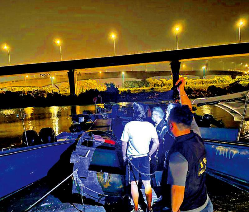 图:被捕疑犯被警员押解到遭扣押的走私大飞上搜集证据.