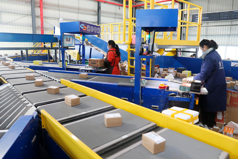 11月10日,在淮北市烈山区一家快递企业分拨中心,工作人员在分拣车间